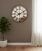 Decorative wall clock on a wall with a plant and curtain in the background