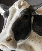 Close-up of a stone sculpture of a cow's head with a dark background
