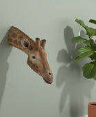 Giraffe head sculpture on a plain background