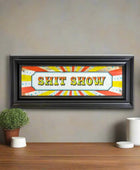 Framed artwork with 'SHIT SHOW' text on a colorful background
