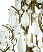 Close-up of a chandelier with white glass shades and gold metalwork.