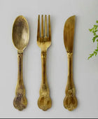 Set of gold-plated spoon, fork, and knife on a white background