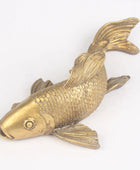 Brass fish-shaped object on a white background