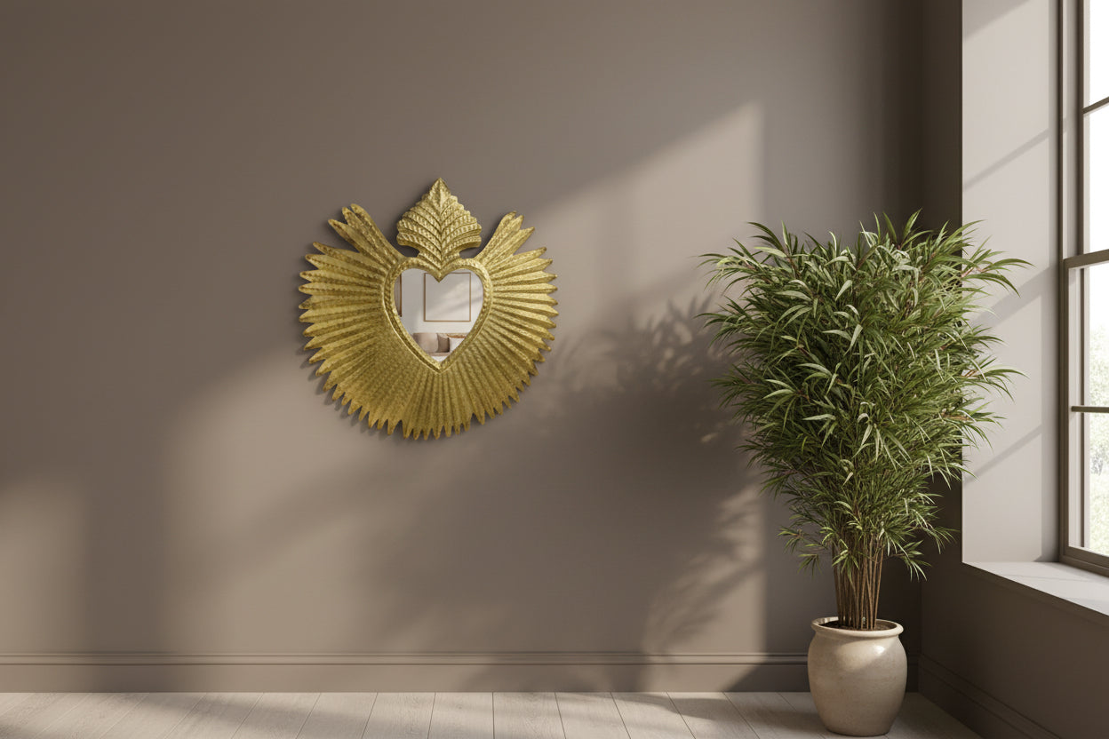 Gold decorative element with heart shape and leaf design on a white background