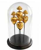 Decorative display of gold hearts under a glass dome on a white background