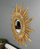 Decorative gold sunburst mirror on a gray wall