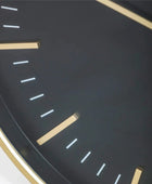 Close-up of a clock face with gold hour markers on a dark background