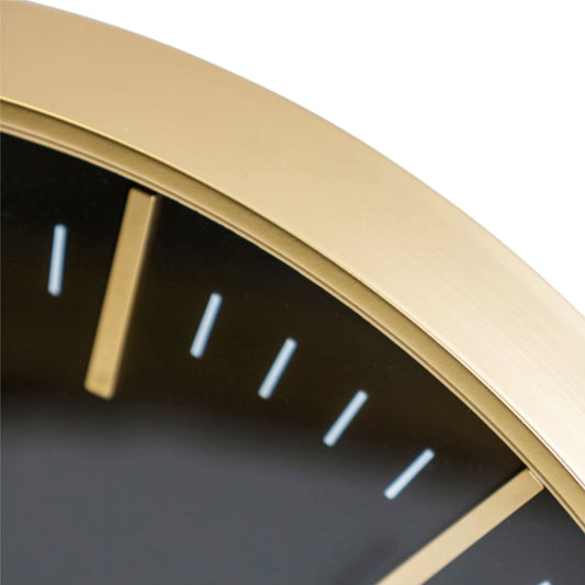 Close-up of a gold-framed clock with black face and white hour markers on a white background