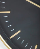 Close-up of a clock face with gold hour markers on a dark background