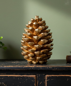 Decorative pine cone on a wooden surface with a green wall background