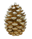Gold ceramic pine cone on a wooden surface with a marble background
