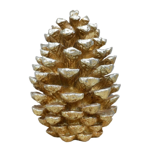Gold ceramic pine cone on a wooden surface with a marble background