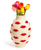 Vase with red lip prints and colorful tulips on a white background