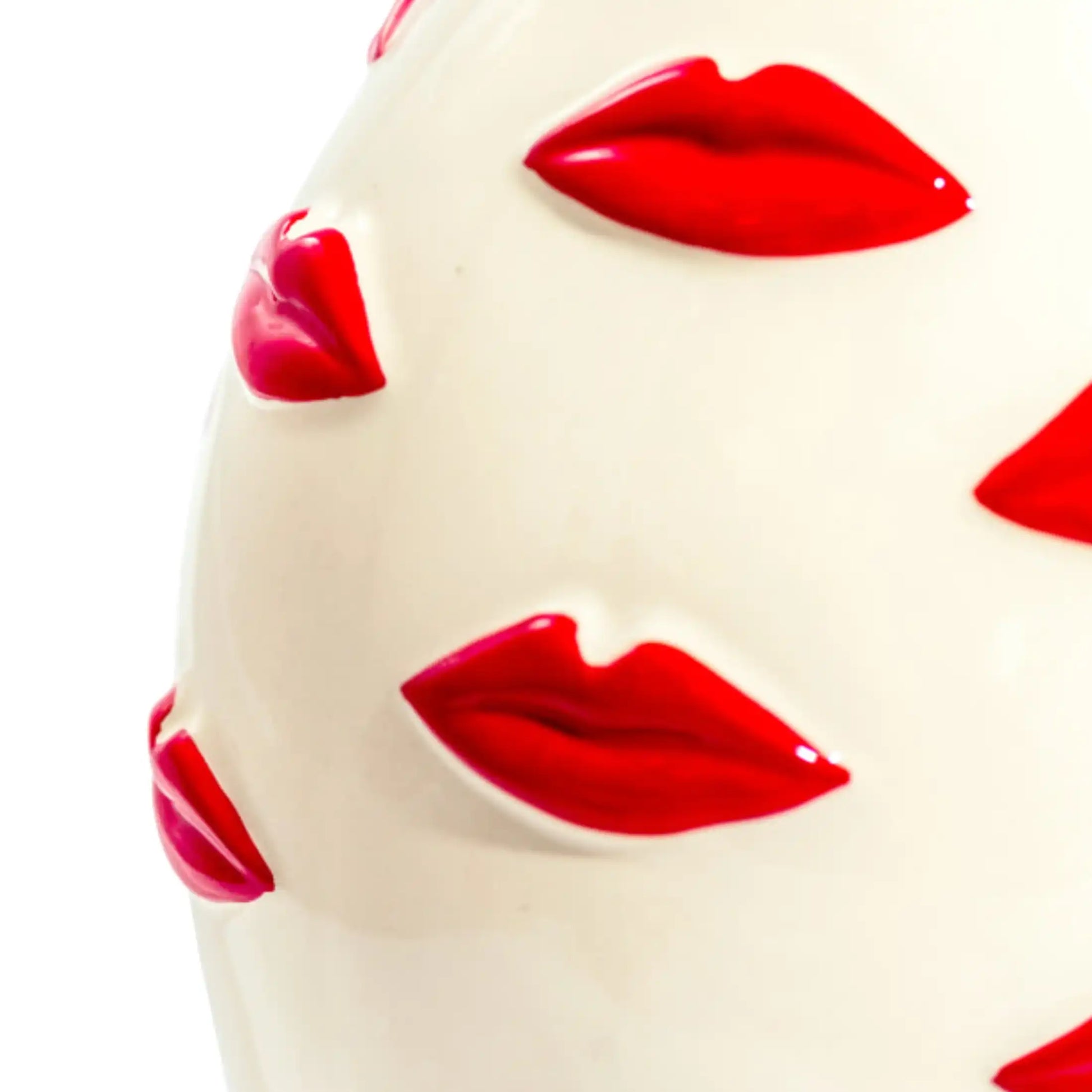 White spherical object with red lips printed on it against a white background