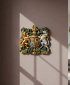 Decorative wall emblem with a lion and unicorn design on a beige wall.
