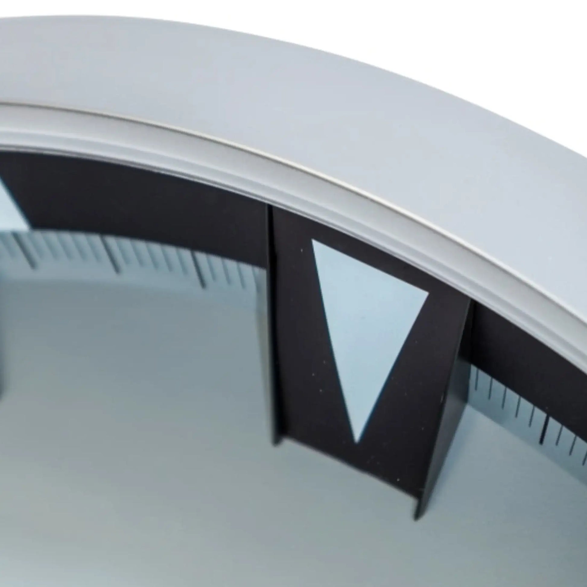 Close-up of a circular object with a black triangle and white border on a light gray background