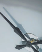 Close-up of a clock with black hands on a light gray background