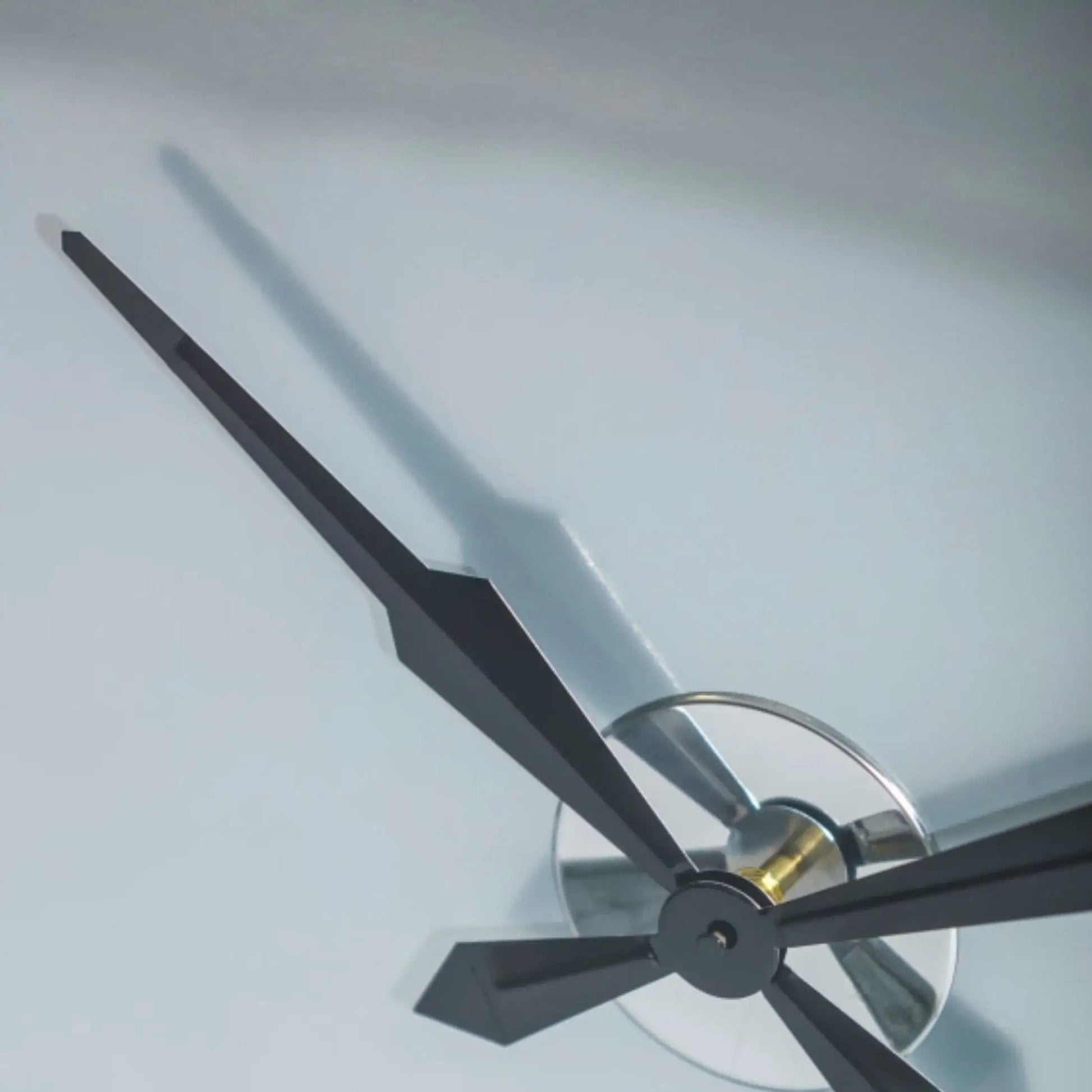 Close-up of a clock with black hands on a light gray background