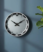 Wall clock on a blue wall with a plant to the right