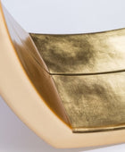 Gold metallic surface with a textured finish on a light gray background