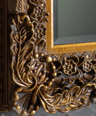 Close-up of an ornate gold frame with intricate designs.