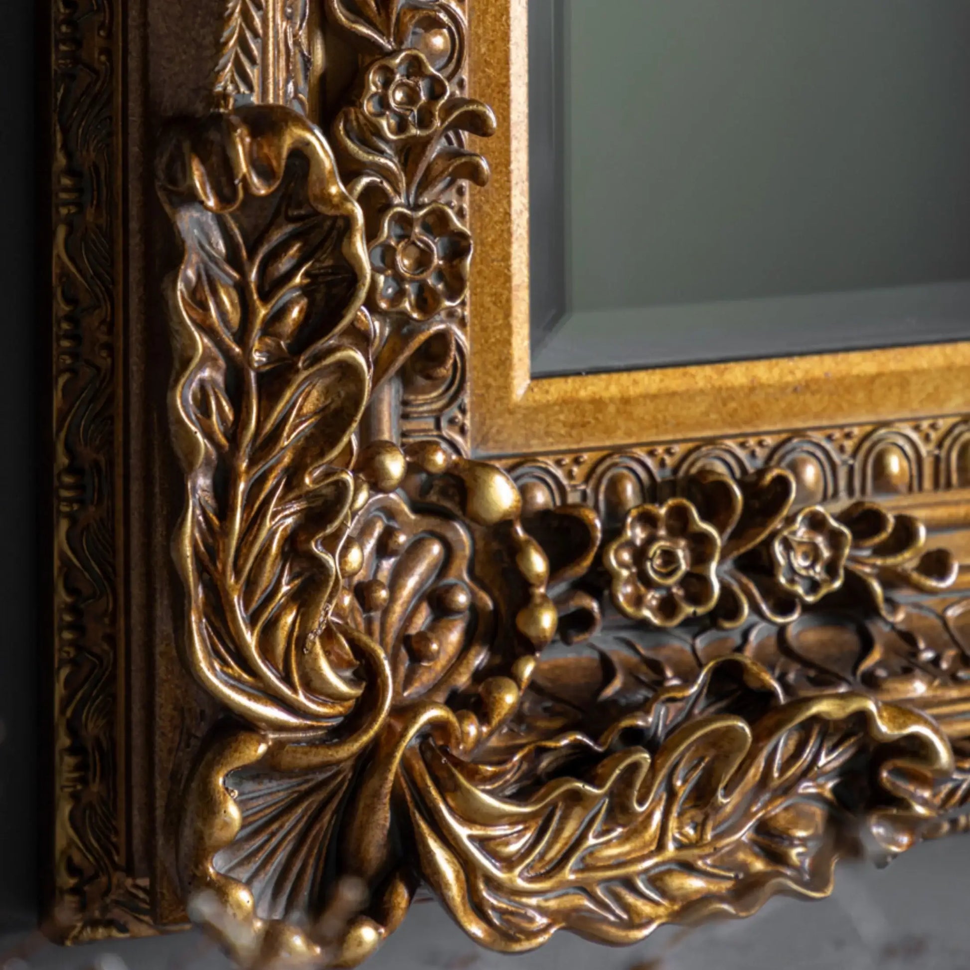 Close-up of an ornate gold frame with intricate designs.
