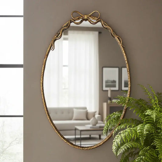 Gold-framed mirror on a wall with a living room in the background