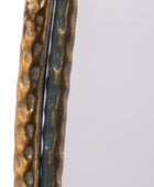 Close-up of a textured bronze or copper object on a light gray background