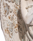 Close-up of a textured surface with intricate patterns and a statue in the background