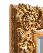 Decorative gold mirror frame with intricate designs on a white background