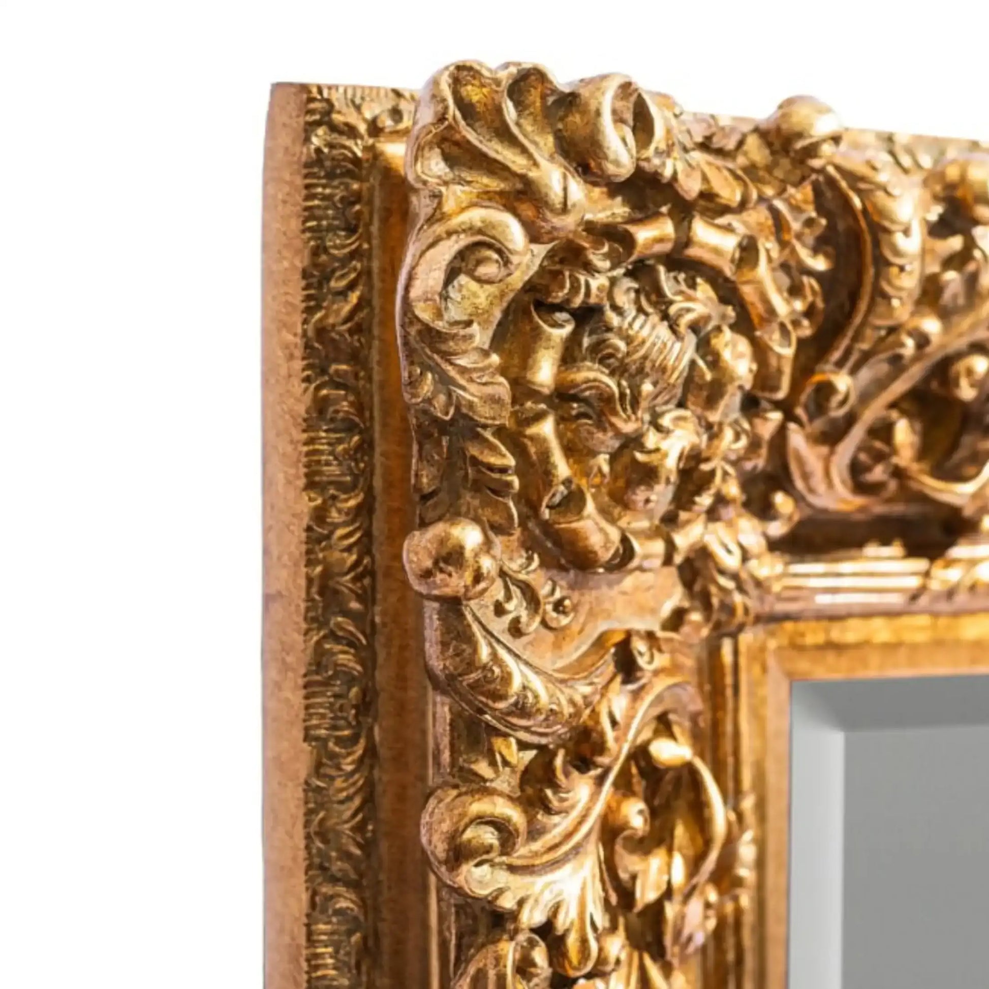 Decorative gold mirror frame with intricate designs on a white background