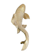 Gold fish-shaped object on a dark surface