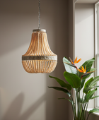 Beaded pendant light hanging in a room with a plant and window.