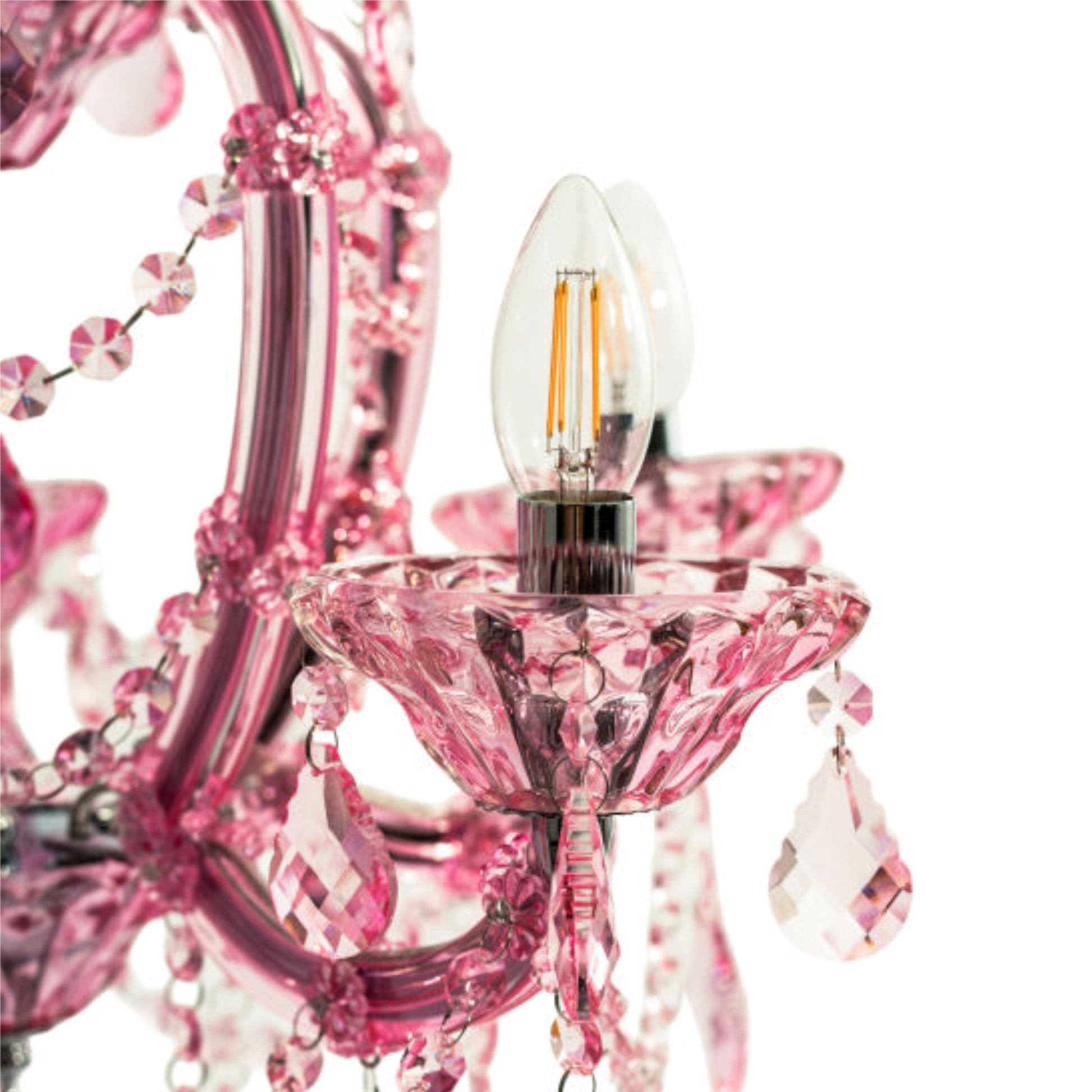 Close-up of a pink crystal chandelier detail with a clear flame-tip bulb, faceted pink glass arms, hanging crystal drops, and a visible filament light bulb on a white background.