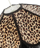Leopard print lampshade with black trim on a white background