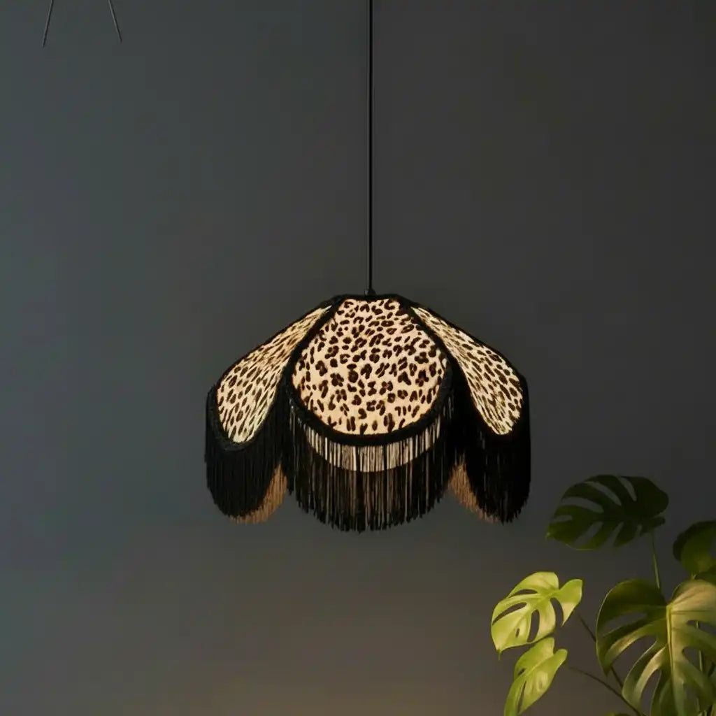 Leopard print pendant light with black fringe against a dark background