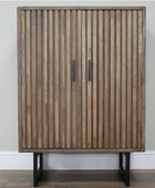 Wooden cabinet with slatted design and black legs against a plain wall.
