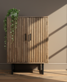 Wooden cabinet with slatted design against a plain wall with a plant on top