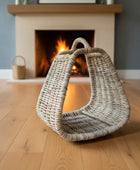 Woven basket on a wooden floor with a fireplace in the background