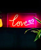 Neon sign with 'love' and heart symbol on a dark background