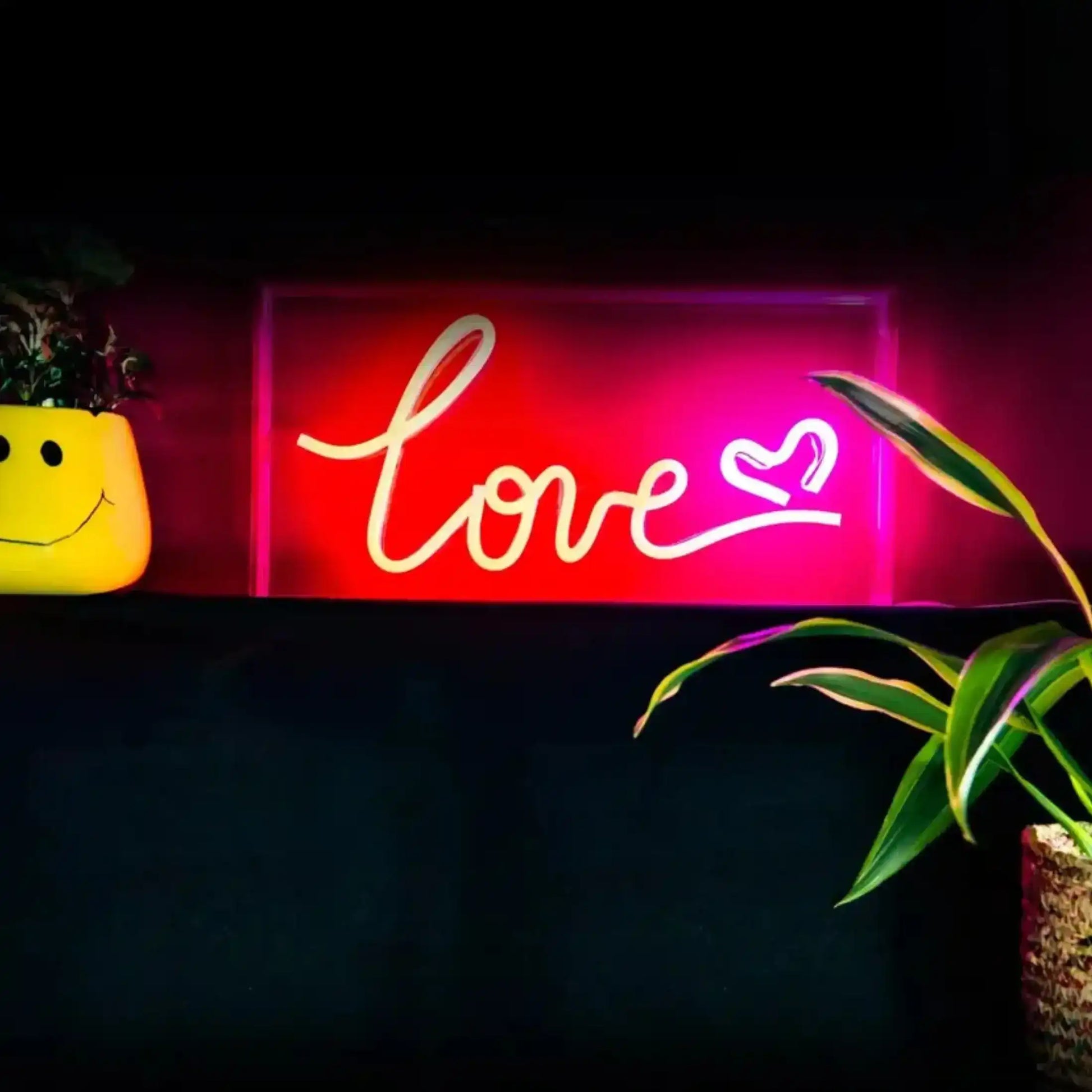 Neon sign with 'love' and heart symbol on a dark background