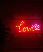 Neon sign with 'love' and heart symbol on a dark background