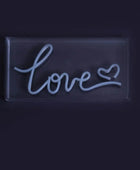 Neon sign with the word 'love' on a black background