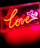 Neon sign with the word 'love' and heart symbols on a black background