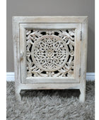 Carved wooden cabinet with intricate patterns on a gray surface