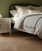 Bedroom with a bed and nightstand against a green wall.
