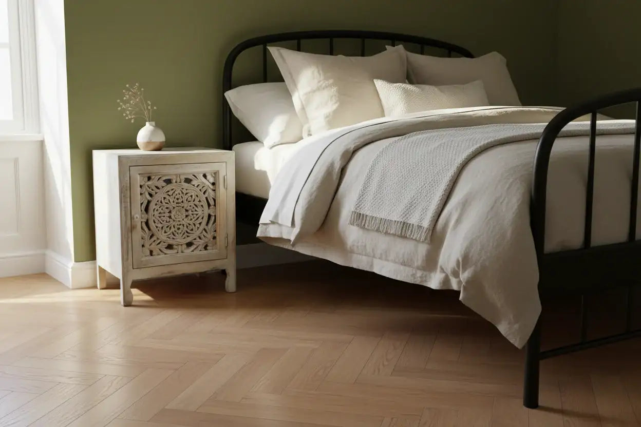 Bedroom with a bed and nightstand against a green wall.