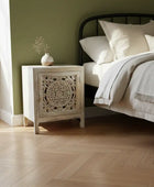 Bedroom with a wooden nightstand and bed with white bedding.