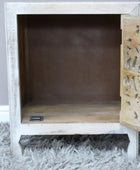 Wooden cabinet with intricate carvings on a gray surface