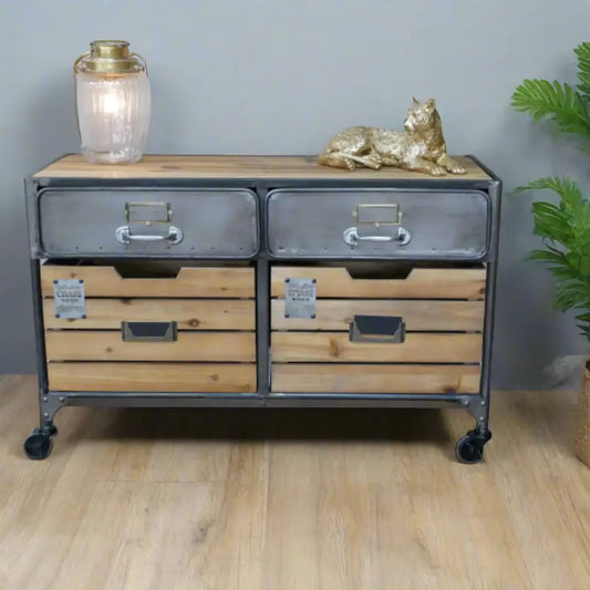Wooden dresser with metal accents on a wooden floor, decorated with a gold cat figurine and a lantern.